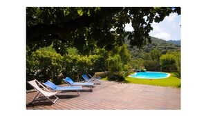 Un espace aménagé au bord de la piscine, avec des chaises longues et une piscine.