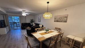 Un coin repas avec une table et des chaises en bois, un ventilateur de plafond et un lustre.