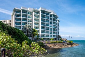 A multi-story hotel with balconies, situated by the sea with a rocky shoreline. - Ocean Lagoon Studio · Balcony (San Juan)