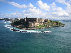 A coastal fortification with a lighthouse, surrounded by the sea. - Ocean Lagoon Studio · Balcony (San Juan)