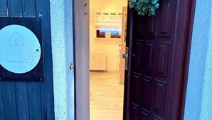 A hotel entrance with a wooden door, a welcome mat, and a sign on the wall. - Vacation apartment Seelenglück with garden 🪴🦮 (Bad Harzburg)