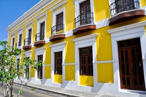 A yellow building with white trim, multiple windows, and balconies. - Stylish Lagoon Studio in Condado · Pool & Hot Tub (San Juan)