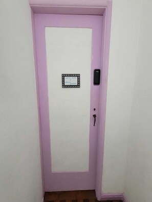 A door with a white panel and a small welcome sign. - Cozy apartment 5 minutes from the Lapa arches, Lolita House (Rio de Janeiro)