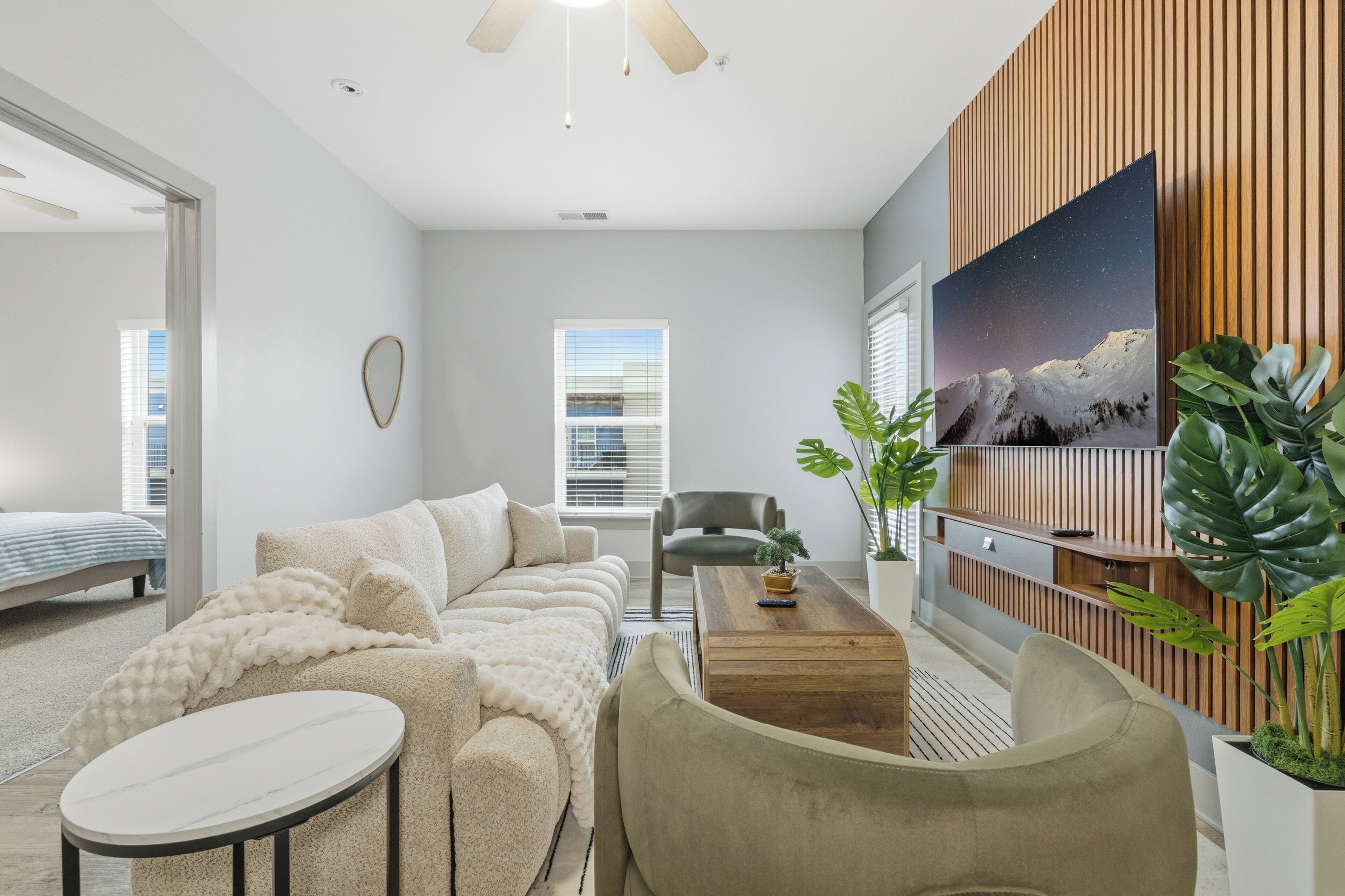 Un salon moderne avec un canapé, une table basse et un tableau accroché au mur.