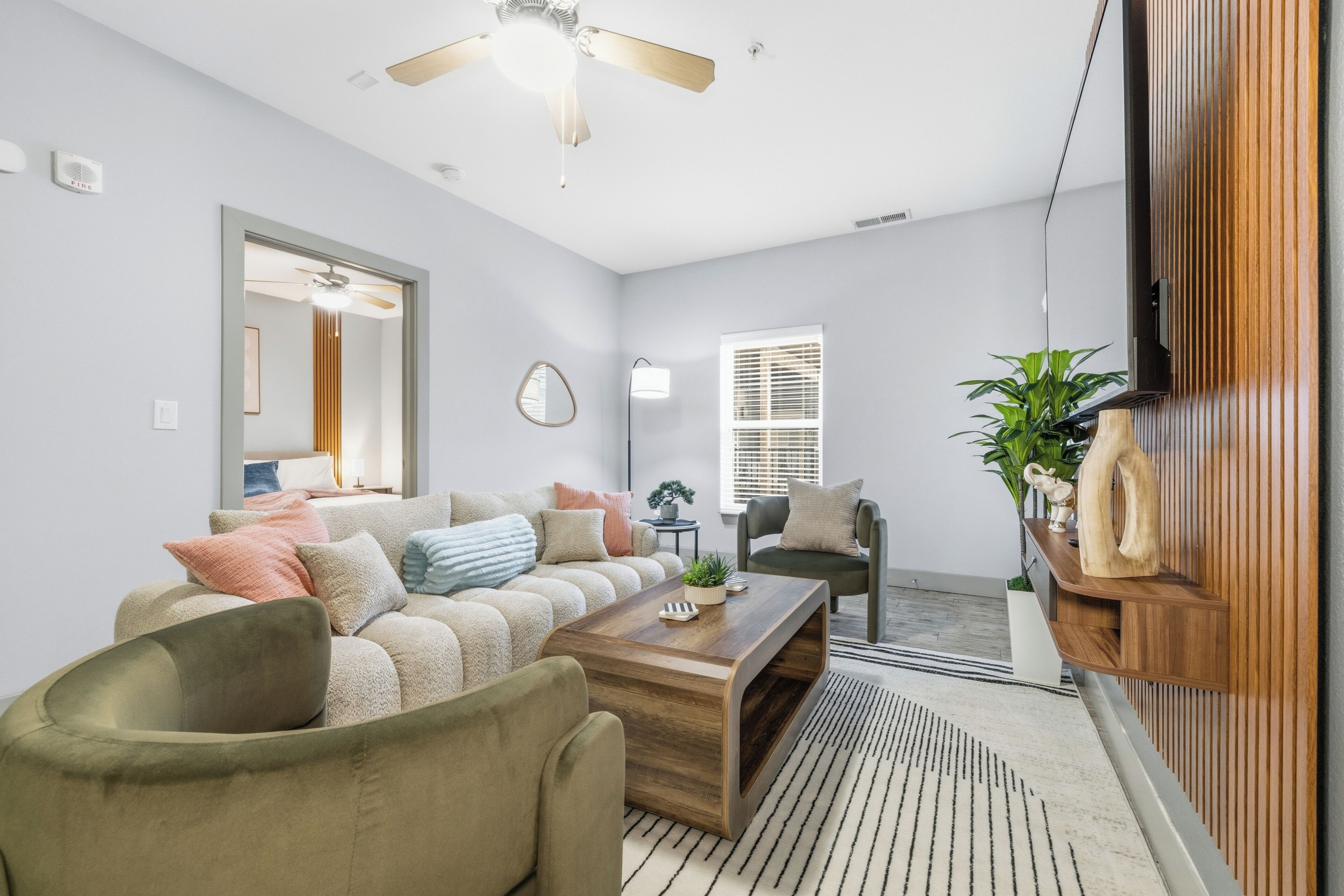 A modern living room with a sofa, coffee table, and a ceiling fan.