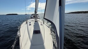 A sailboat's deck with a clear view of the water and distant land. - Enjoyable 3-bedroom boat in charming Stockholm for a unique stay (Stockholm)