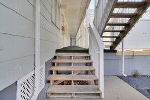 A wooden staircase leading to a porch with a green mat at the top. - Jocelyn Manor 86 | Pet Friendly 1BR Beach Condo (Ocean City)