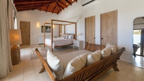Ein Schlafzimmer mit einem Himmelbett, einer Holzbank und einem großen Spiegel.
