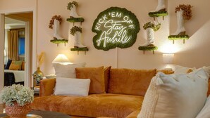 Ein gemütliches Wohnzimmer mit einer Couch, Wanddekoration und einer Lampe.