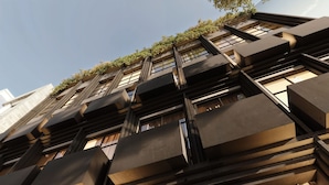 Un edificio moderno con fachada geométrica, amplias ventanas y tejado plano.