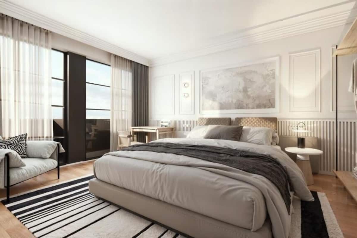 Quarto moderno com uma cama grande, espaço de estar e um guarda-roupa.