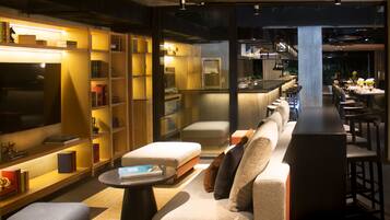 A modern interior with a sofa, ottoman, and a bar area.