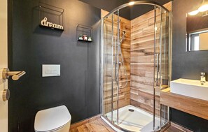 A modern bathroom with a glass-enclosed shower, a white toilet, a wooden vanity, and a dark wall with a 'dream' sign. - Gorgeous home in Zminj (Zminj)