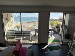 A room with a view of the sea, a patio with outdoor furniture, and a sliding glass door. - Waterfront apartment, the sea 10 metres away! (La Ciotat)
