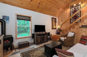 Living area - Cozy 3-bedroom log cabin nestled in the peaceful woods of central Maine (New Portland)