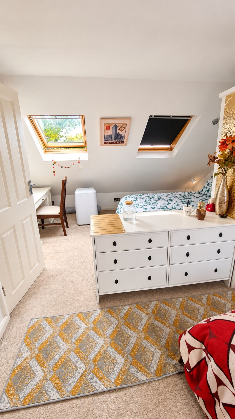 A bedroom with a bed, a dresser, a window, and a door.