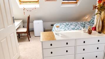 A bedroom with a bed, a dresser, a window, and a door.