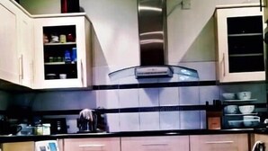 Una cocina con armarios, lavadora y una alfombra verde.