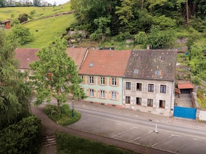 A residential street with houses, a clear road, and a hillside in the background.