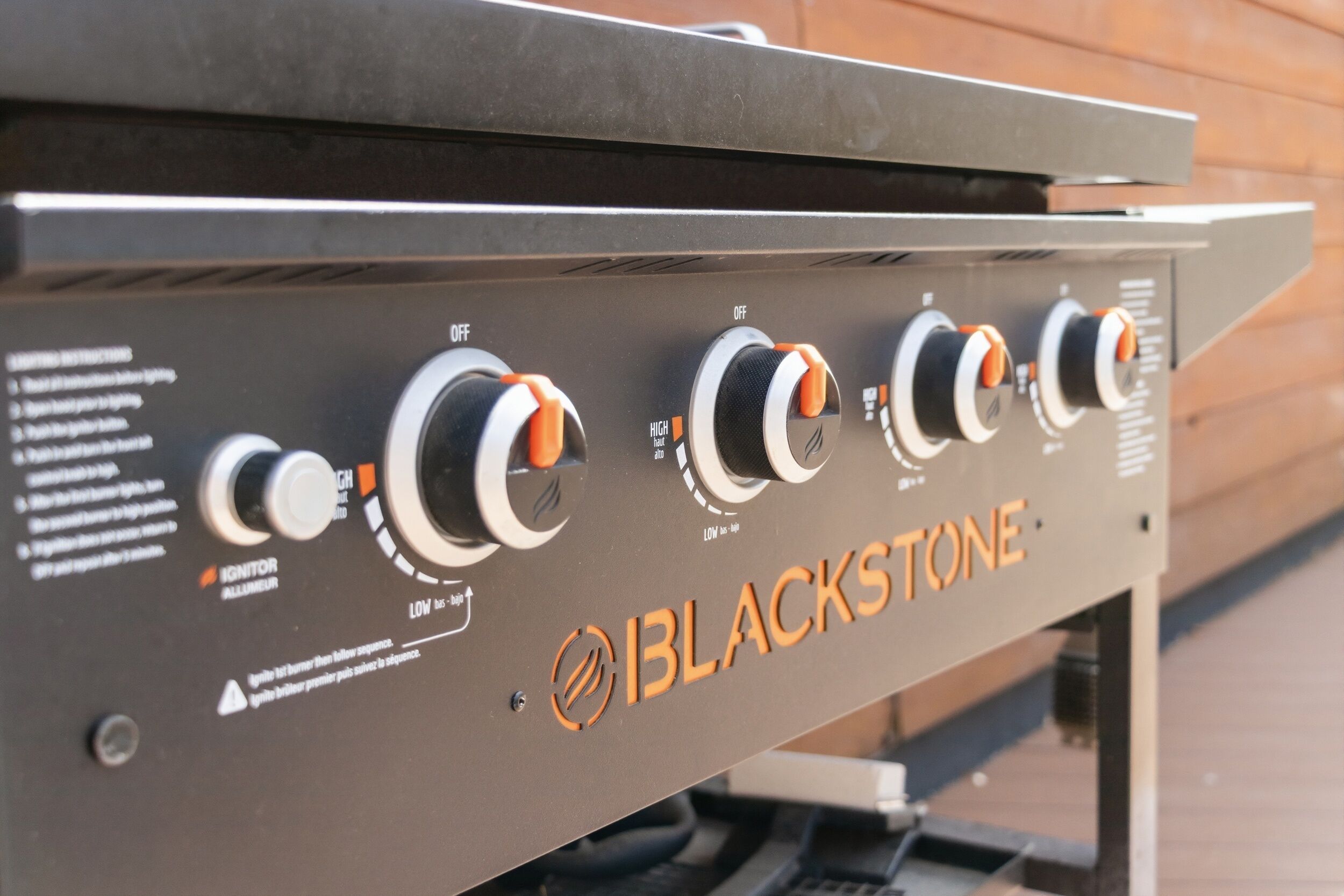 Un panneau de commande pour le gril, doté de quatre boutons, d’une étiquette d’avertissement et du nom de la marque « BLACKSTONE ».