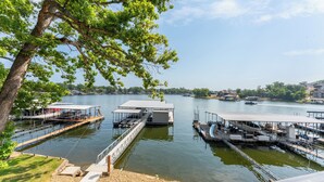 A lakeside dock with multiple boat slips and a covered seating area. - 40’ Boat Slip-New Luxury Lakefront-3 King Beds-Sleeps 12-21MM (Osage Beach)