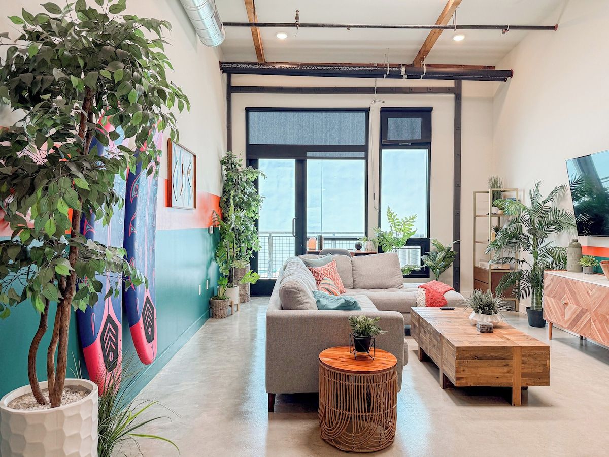 A modern living room with a sofa, coffee table, and potted plants.
