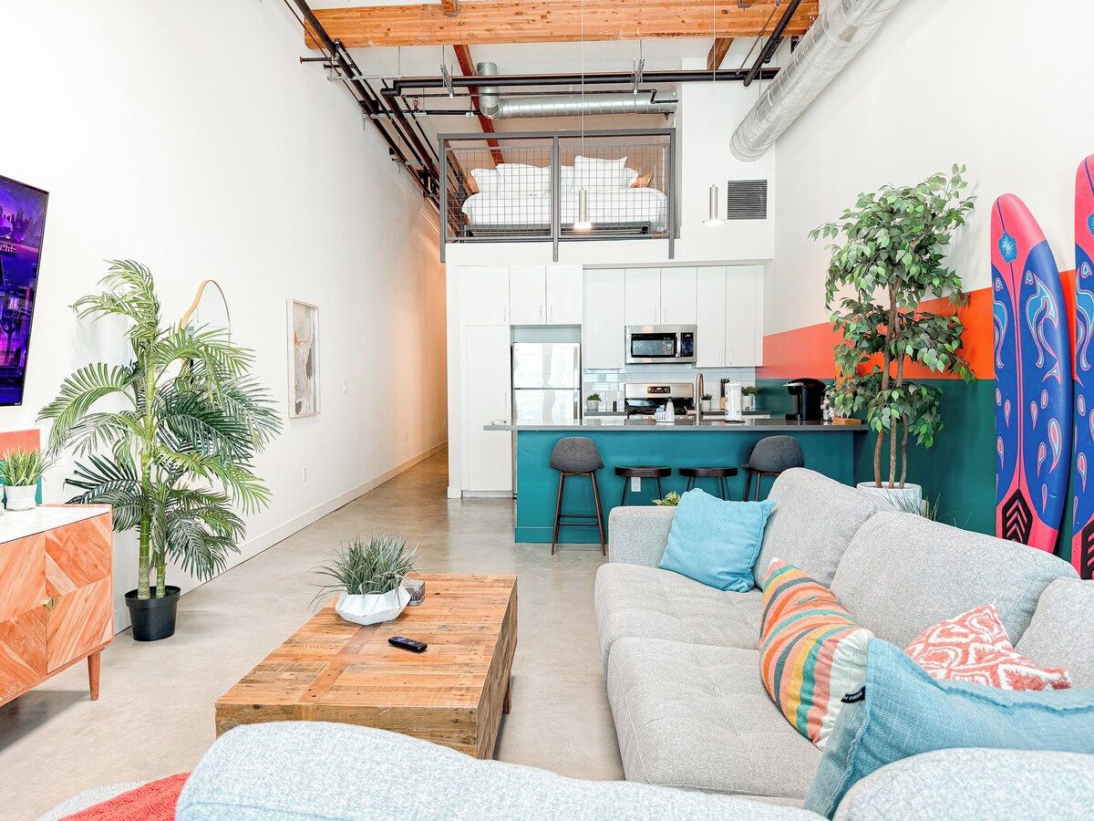 A modern living space with a sofa, coffee table, and a kitchen area in the background.