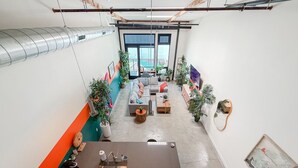 Een moderne kantoorruimte met een centraal zitgedeelte, een kitchenette en grote ramen.