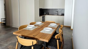 Une cuisine compacte avec un coin repas, comprenant une table dressée pour quatre personnes, avec assiettes et couverts.