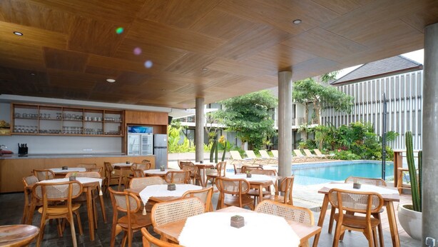 A restaurant with outdoor seating, a pool, and a bar area. - THE LEDGE ULUWATU (Pecatu)
