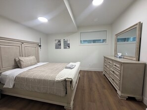 Una camera da letto con un letto, una cassettiera e uno specchio.