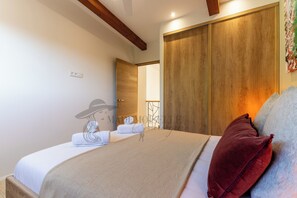 A hotel room with a bed, a wooden wardrobe, and a painting on the wall. - 2 Villas • Beach • Pools • Large groups (Agde)