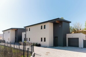 Ein modernes Gebäude mit Flachdach, Garage und Kiesweg.
