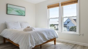 Un dormitorio con cama, ventana y un cuadro en la pared.