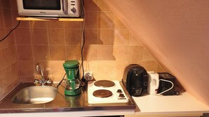 A compact kitchen with a microwave, toaster, coffee maker, and dishwasher. - Lovely studio 5 minutes from Kerambigorn beach (Fouesnant)