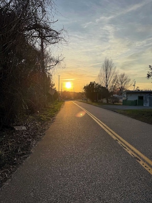 Una carretera con cielo despejado y el sol poniéndose o saliendo.