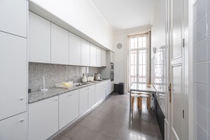 Eine moderne Küche mit weißen Schränken, einer Granitarbeitsplatte und einem Essbereich mit Hockstühlen.