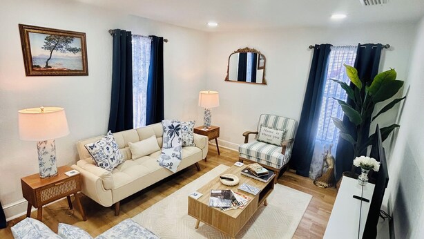 A living room with a sofa, armchair, coffee table, side table, lamp, and a television. - “Up in the hill” is a charming, 1 bedroom apartment located in Haines City (Haines City)