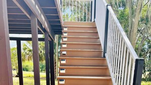A wooden staircase with white railings leading to an outdoor area. - “Up in the hill” is a charming, 1 bedroom apartment located in Haines City (Haines City)