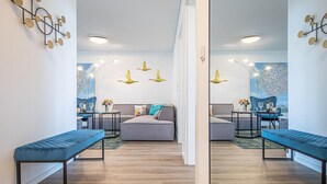 Una sala moderna con un sofá, dos mesitas auxiliares y un banco.