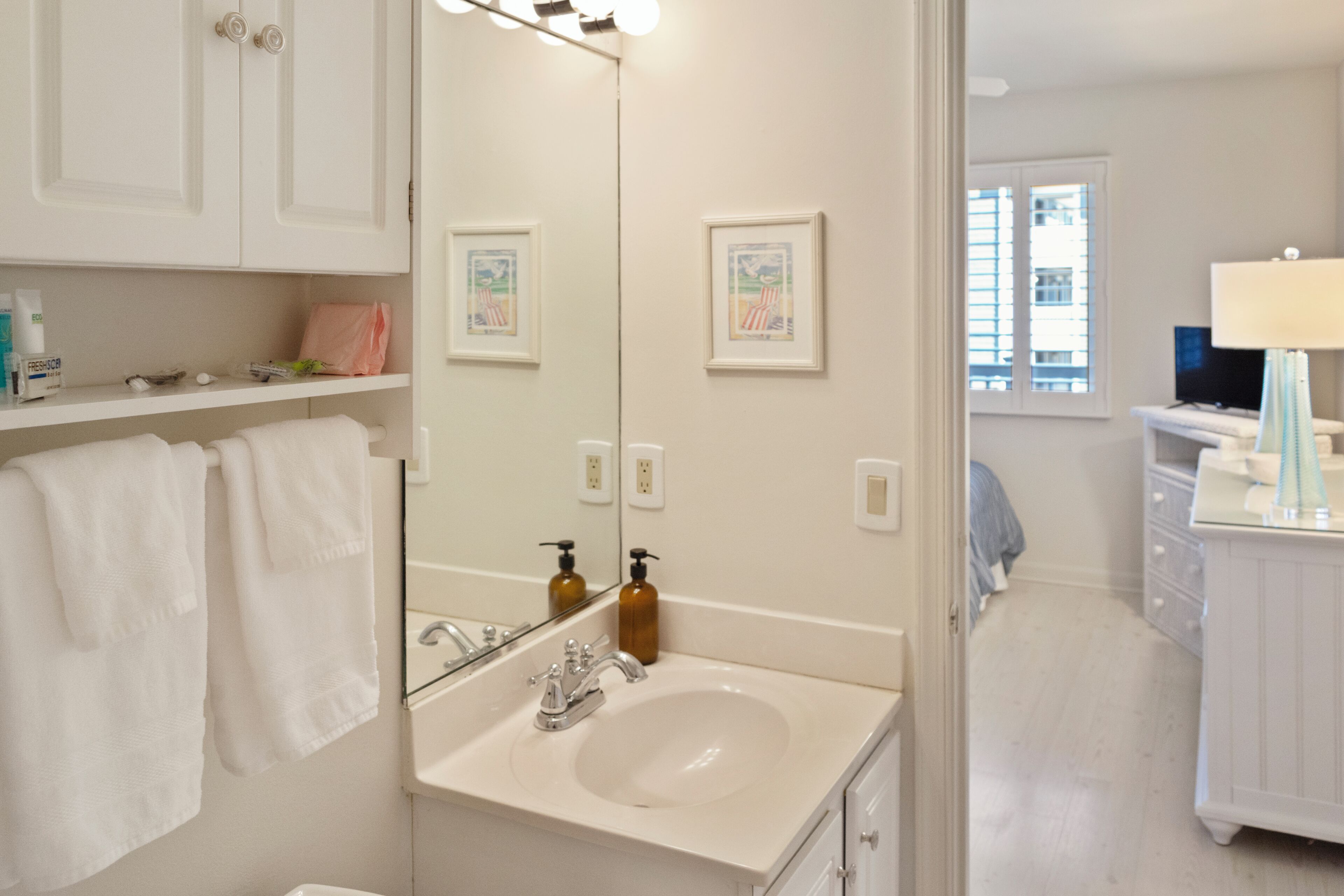 A bathroom with a sink, mirror, and towels.