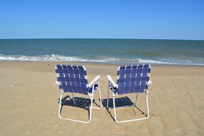 Twee strandstoelen gericht op de zee.