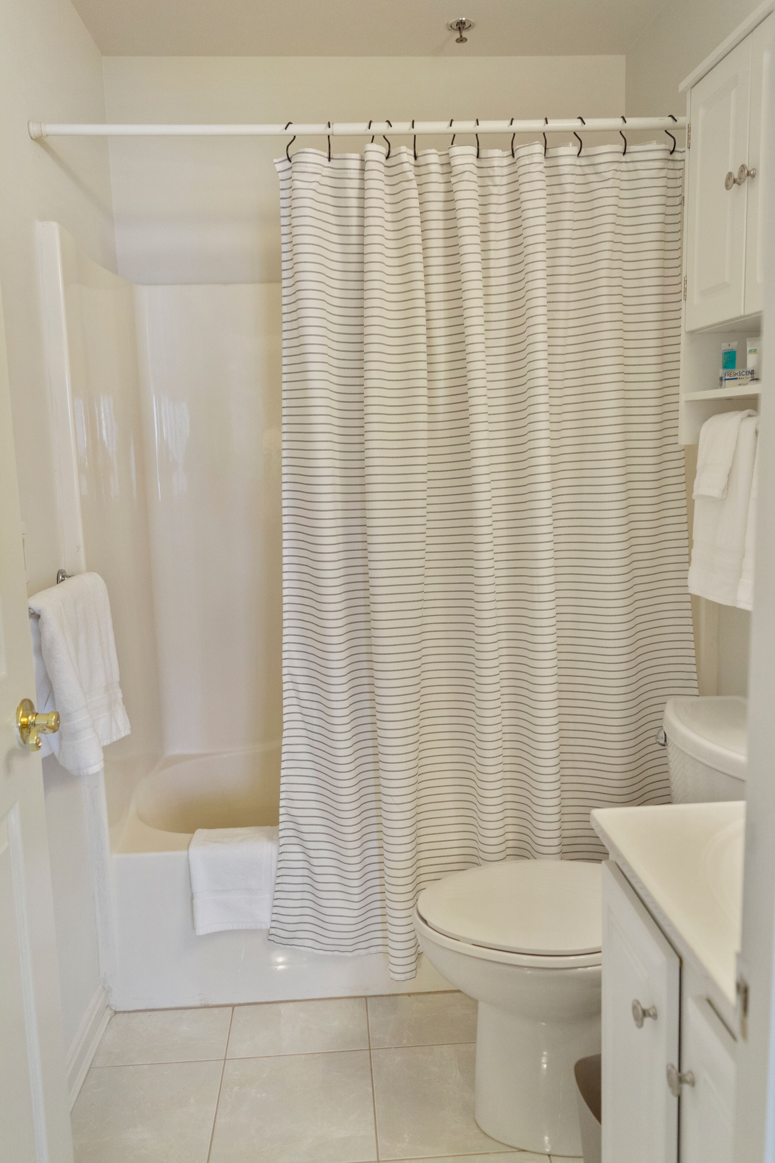 A bathroom with a shower, toilet, and a bathtub.