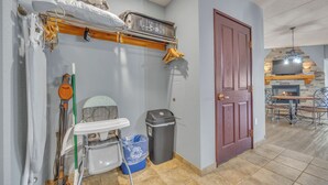 A compact kitchen with a built-in stove, a dining area with a table and chairs, and a door leading to another room. - High Tides - Sleeps 14 | Video Games (Wisconsin Dells)