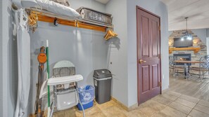 A compact kitchen with a built-in stove, a dining area with a table and chairs, and a door leading to another room. - High Tides - Sleeps 14 | Video Games (Wisconsin Dells)