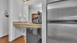 A kitchenette with a stainless steel refrigerator, a microwave, a sink with soap dispenser, and a dish drying rack. - High Tides - Sleeps 14 | Video Games (Wisconsin Dells)