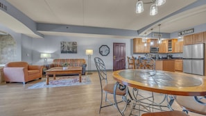 A modern kitchen with stainless steel appliances, a dining area with a round table, and a living room with a sofa and a coffee table. - High Tides - Sleeps 14 | Video Games (Wisconsin Dells)