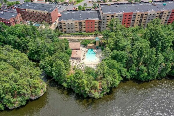 A hotel with a swimming pool surrounded by dense greenery. - High Tides - Sleeps 14 | Video Games (Wisconsin Dells)