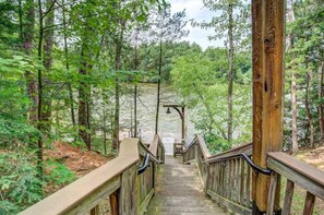 A wooden staircase leading into a forested area with a wooden railing. - High Tides – Spacious Condo Sleeps 14 with Video Games (Wisconsin Dells)