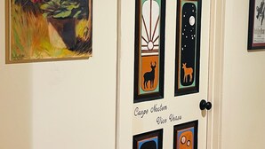 A door with multiple framed artworks, including a painting of flowers and various animal silhouettes.